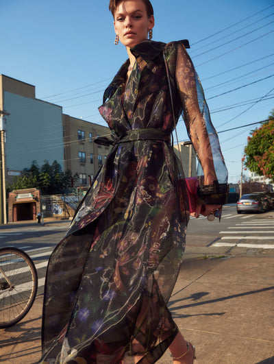 A model poses outside in an Oscar de la Renta floral tulle trench coat. 