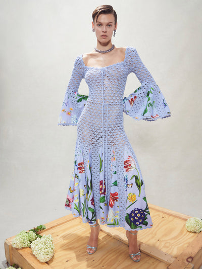 A model poses inside in an Oscar de la Renta blue floral detail crochet dress.