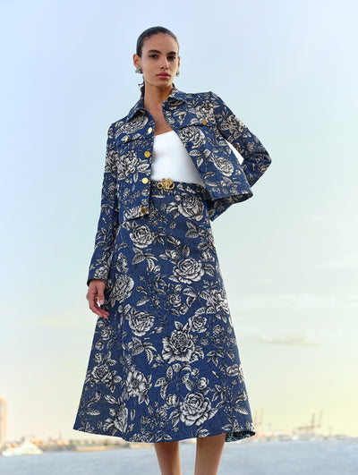 The model poses in a matching blue and white floral denim midi skirt and jacket from Oscar de la Renta's Spring 2025 collection. 