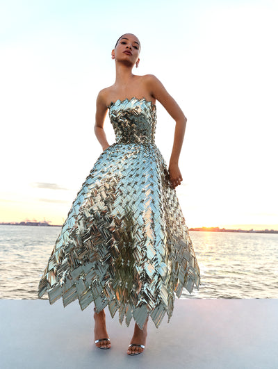 The model poses in a pale mint dress composed of woven sequins and geometrically placed crystals from Oscar de la Renta's Spring 2025 collection. 