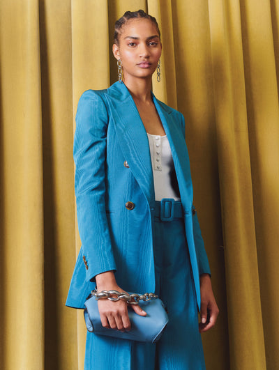 A model wears a blue suit set with a white top