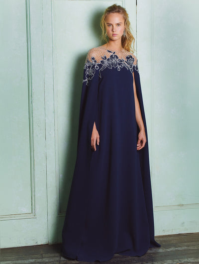 A model wears a navy caftan with flowers and crystals embroidered