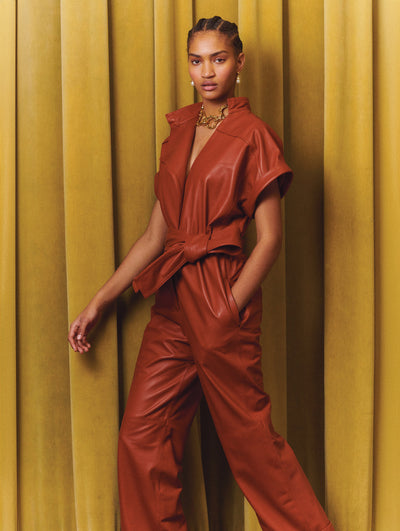A model wears a burnt orange leather suit set