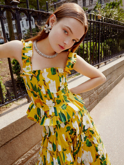 A model wears an Oscar de la Renta matching floral cotton poplin blouse and skirt set on the sidewalk. 