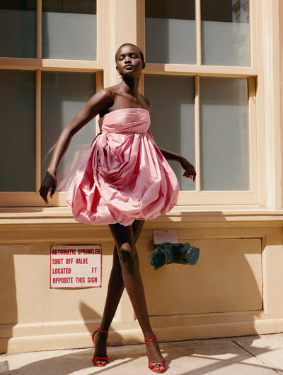 A model poses outside in an Oscar de la Renta pink cocktail dress.