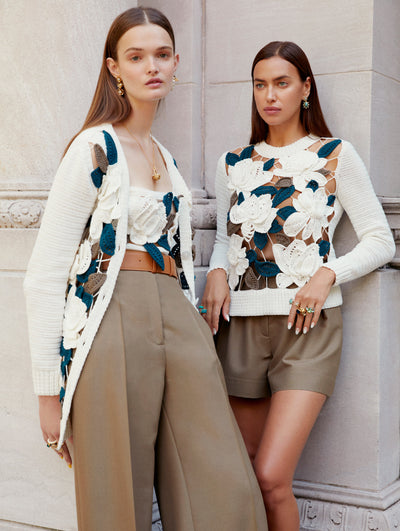 Two models pose against a wall in Oscar de la Renta floral embroidered knitwear styles. 