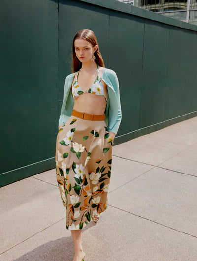 A model walks towards the camera in a floral Oscar de la Renta cardigan, bralette and skirt. 