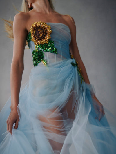 Close up of model wearing strapless tulle dress with embroidered sunflower in the sides from Fall 2021 