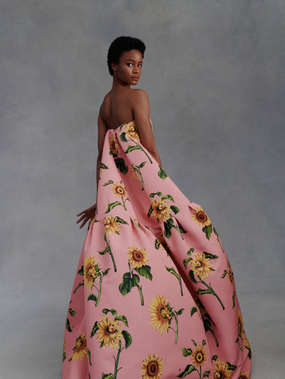Model poses from the back in a pink strapless gown with yellow sunflowers from Fall 2021.