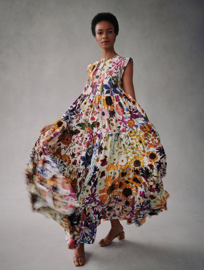 The model wears a poplin floral print long dress with short sleeves and a flowy skirt from Fall 2021