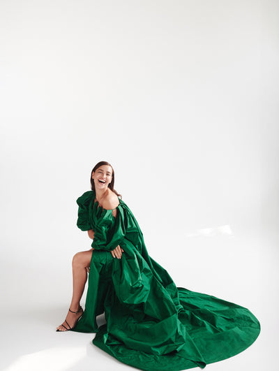 A model wears a long green dress