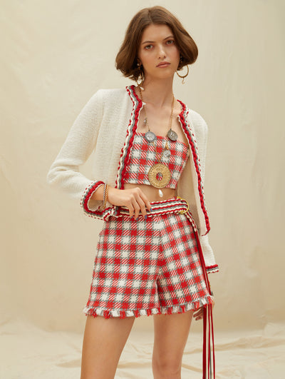 A model wears a red white and grey set short pants, cropped top and cardigan