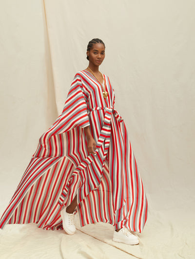 A model wears a long red white and grey striped caftan