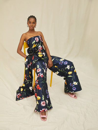 A model wears a navy pantsuit with colorful flowers