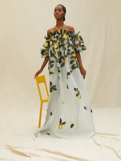 A model wears an off the shoulder blue caftan with lemons