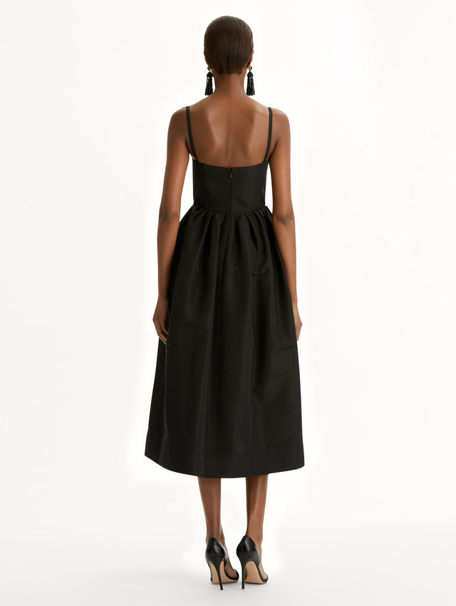 Black Bustier-Detailed Faille Dress with thin straps, a bustier bodice, and midi length skirt. Back View.