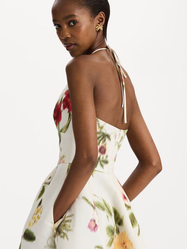 The model is wearing the Chiné Dominican Mixed-Floral Faille Cocktail Dress. Featuring a halter neckline, structured bodice, midi skirt, and belt at waist. Detail View.