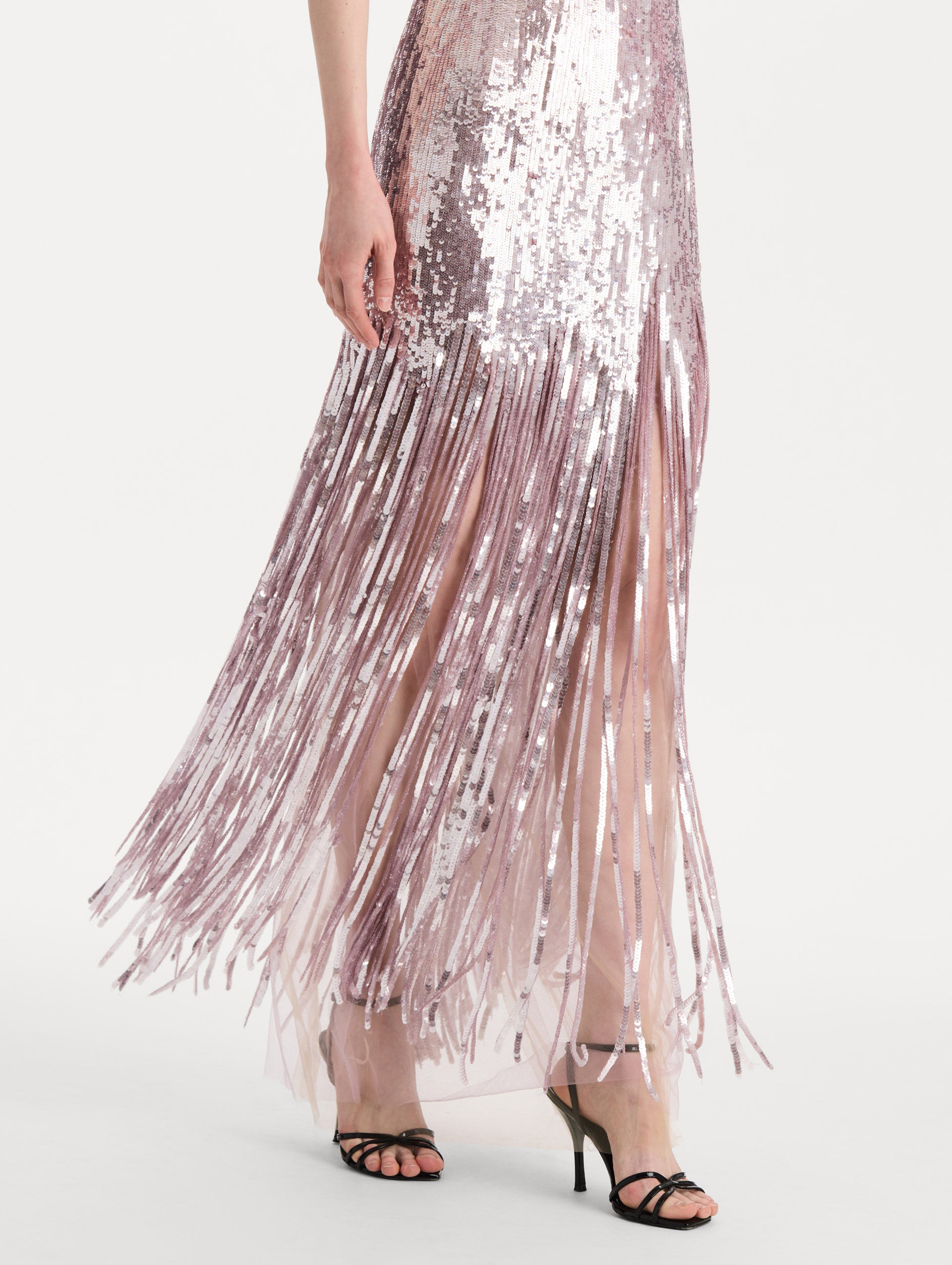 The model is wearing the Sequin Fringe Strapless Gown in the color tulip pink featuring a strapless silhouette, all-over sequins, and fringe skirt. Detail Shot.