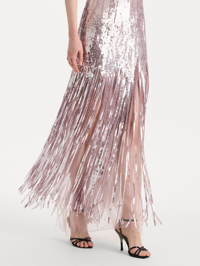 The model is wearing the Sequin Fringe Strapless Gown in the color tulip pink featuring a strapless silhouette, all-over sequins, and fringe skirt. Detail Shot.