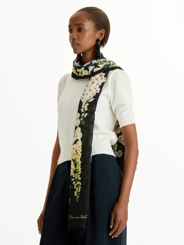 Black Foxglove Cashmere-Blend Scarf with yellow, pink, blue, and purple floral pattern and the Oscar de la Renta logo. Side View.