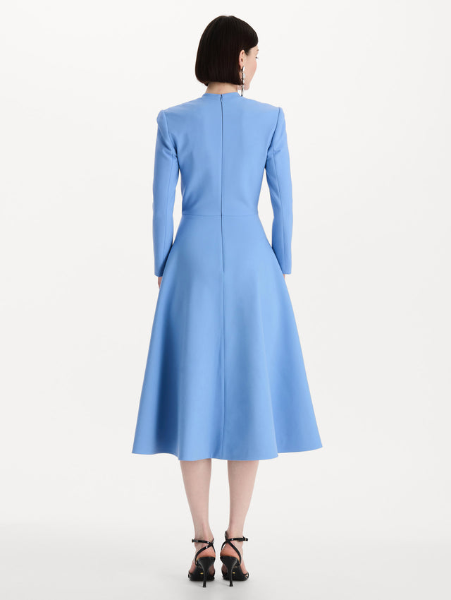 The model is wearing the Wool-Blend Long-Sleeve Dress in the color Hydrangea blue. Featuring a sculpted wrap bodice, long sleeves, and a flared skirt. Back View.