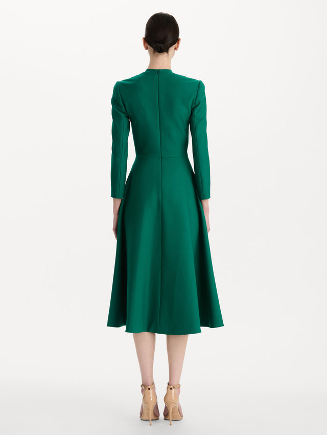 The model is wearing the Wool-Blend Long-Sleeve Dress in the color Malachite green. Featuring a sculpted wrap bodice, long sleeves, and a flared skirt. Back View.