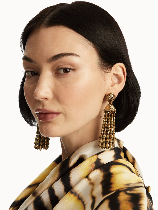 The model is wearing gold chandelier beaded earrings. Front view