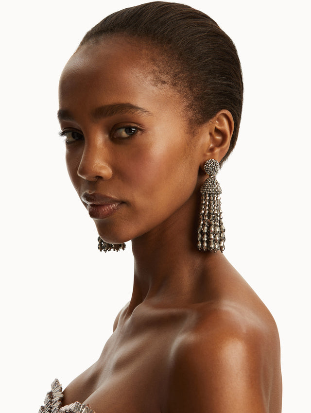 The model is wearing silver chandelier beaded earrings. Front view