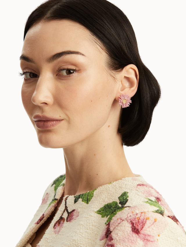 The model is wearing pink pom pom flower beaded earrings. Front view.
