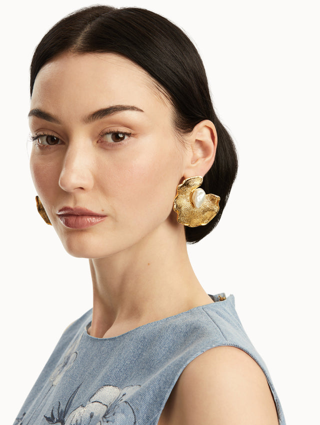 model is wearing large lily pad earrings with a pearl in the center. Front view