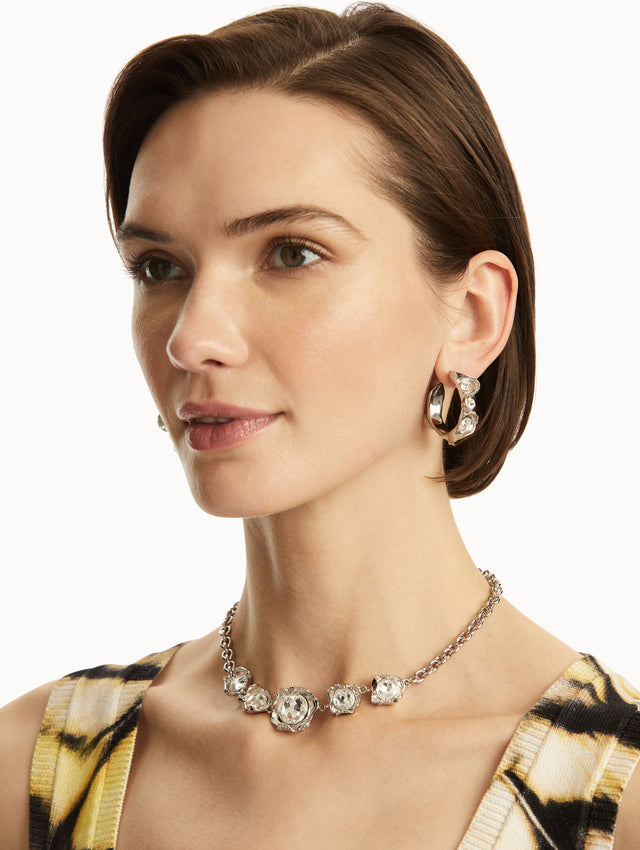 The model is wearing silver textured hoops with crystals embedded, paired with a matching necklace. Front View