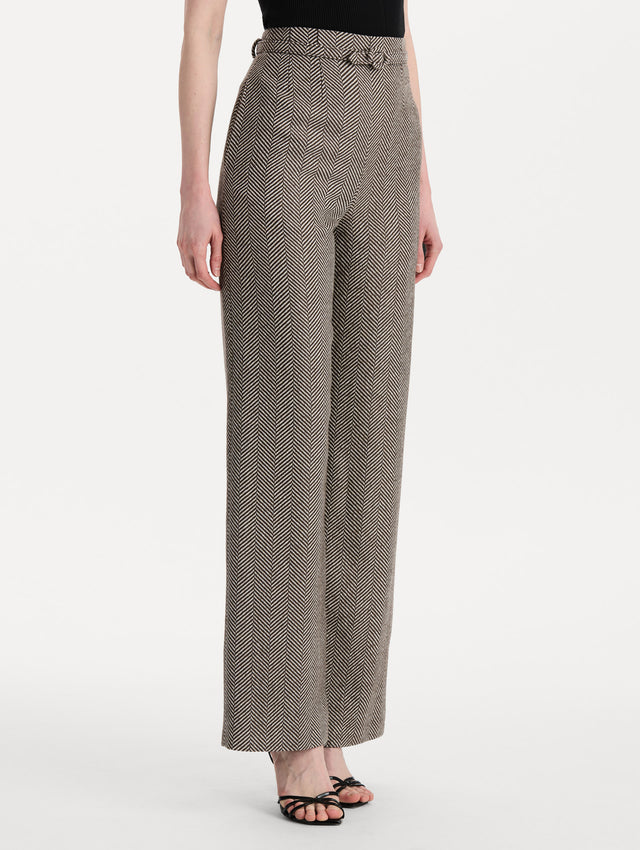 The model is wearing the Chevron Cashmere-Blend Pant featuring a high waist, pockets, and coordinating belt. Side View.