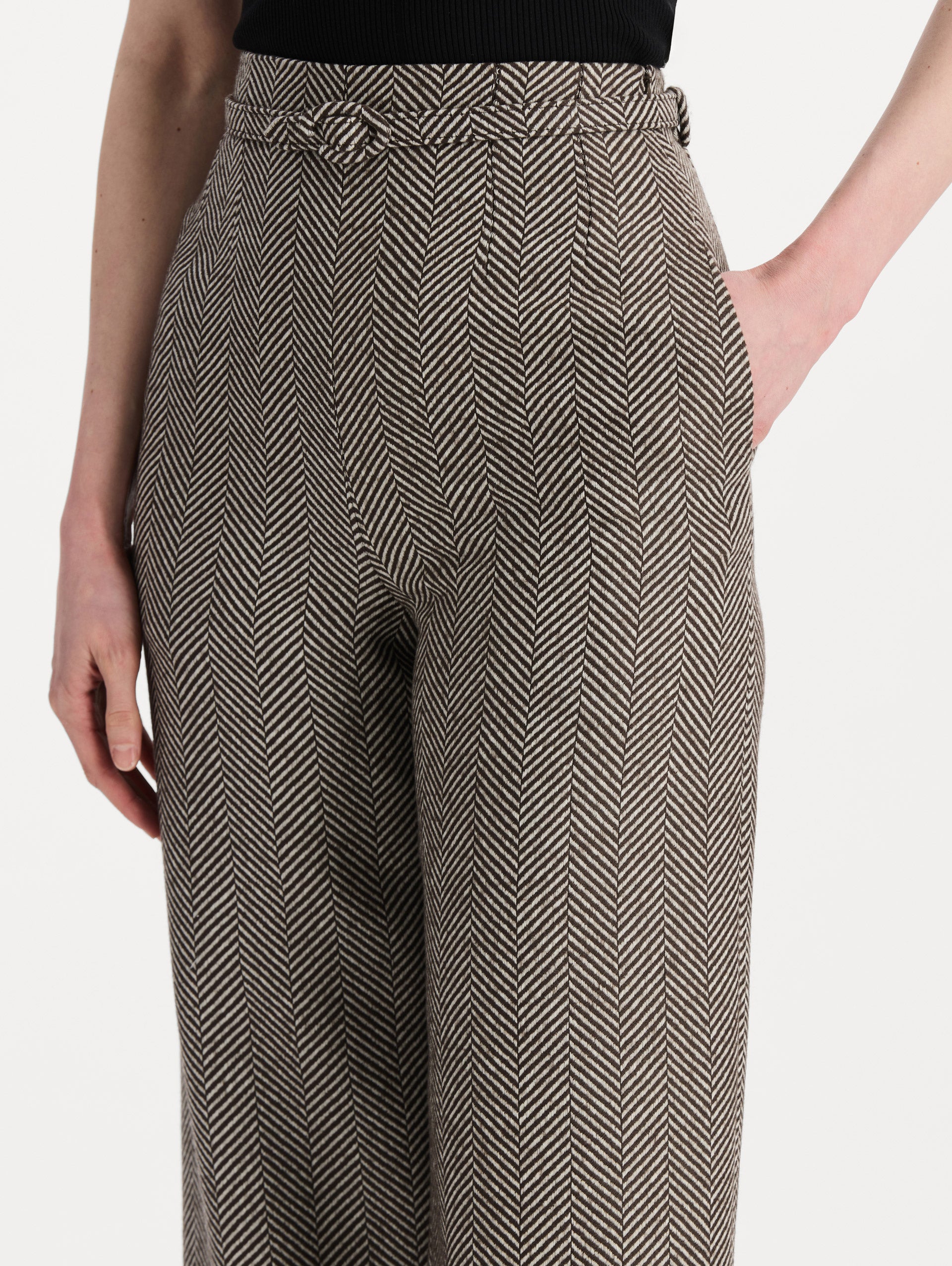 The model is wearing the Chevron Cashmere-Blend Pant featuring a high waist, pockets, and coordinating belt. Detail Shot.