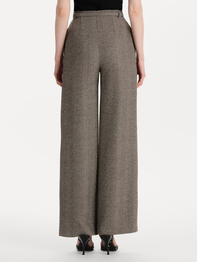 The model is wearing the Chevron Cashmere-Blend Pant featuring a high waist, pockets, and coordinating belt. Back View.