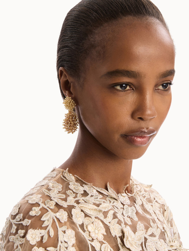 The model is wearing the Beaded Cluster Drop Earrings. Detail View.