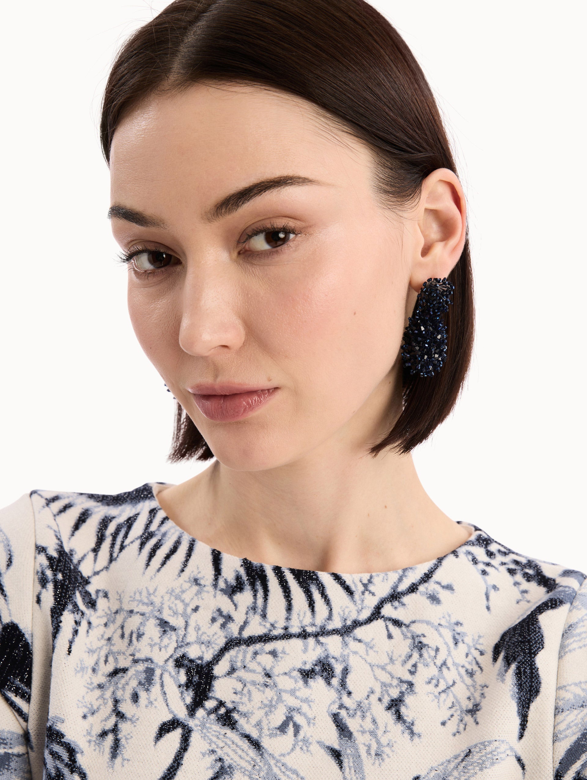 The model is wearing the Beaded Cluster Drop Earrings in Navy. Detail View.