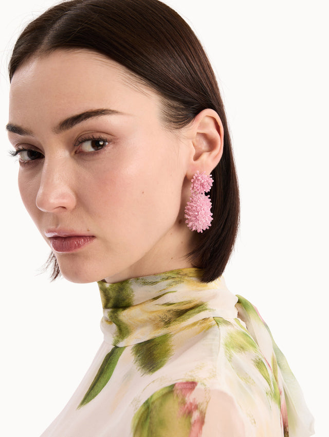 The model is wearing the Beaded Cluster Drop Earrings in Rose. Detail View.