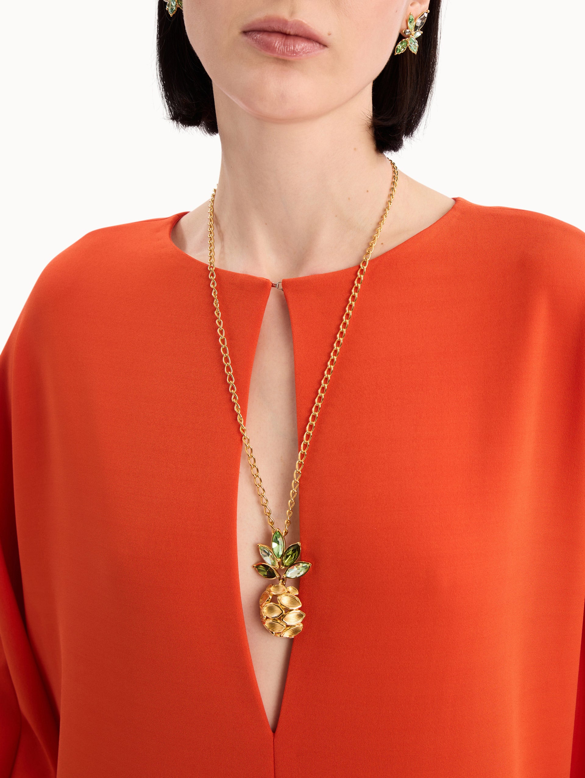 The model is wearing the Pineapple Crystal Leaf Pendant Necklace in Gold. Front View.