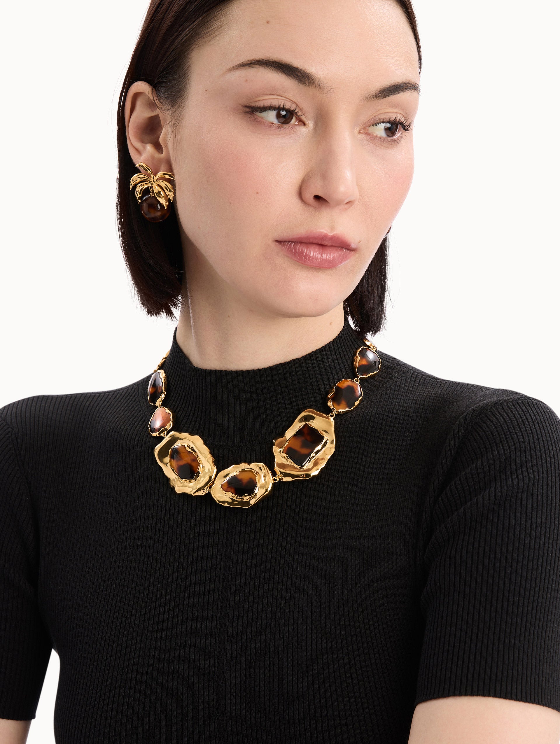 The model is wearing the Tortoise Stone Collar Necklace in Gold and Tortoise. Detail View.