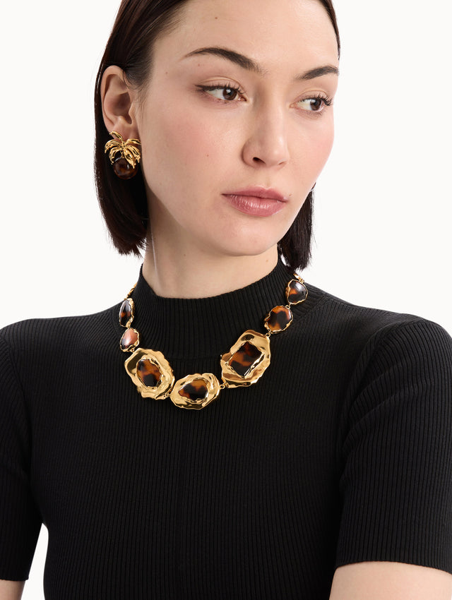 The model is wearing the Tortoise Stone Collar Necklace in Gold and Tortoise. Detail View.