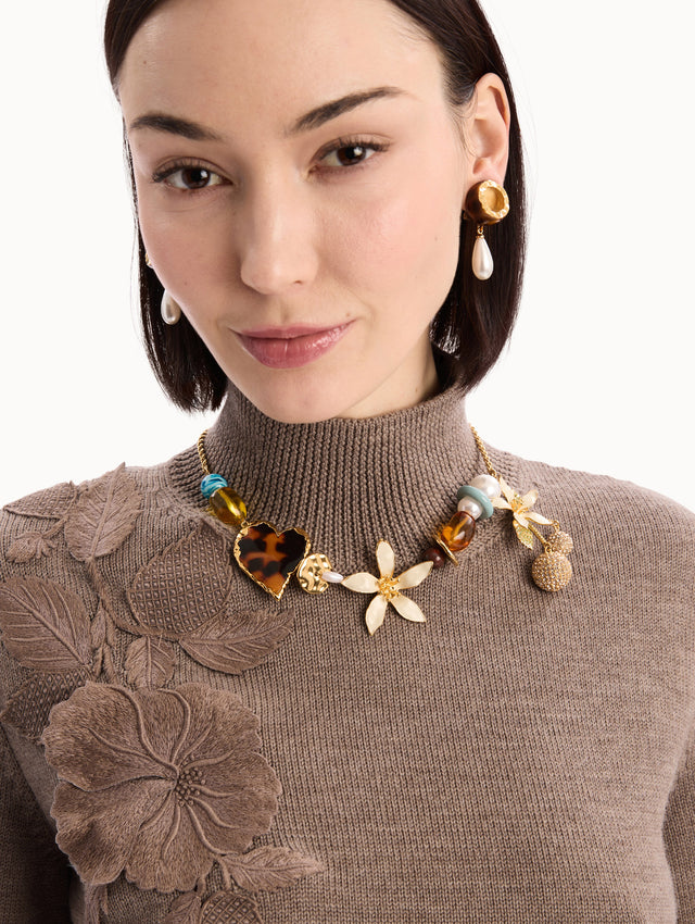 The model is wearing the Orange Blossom Charm Necklace. Front View.