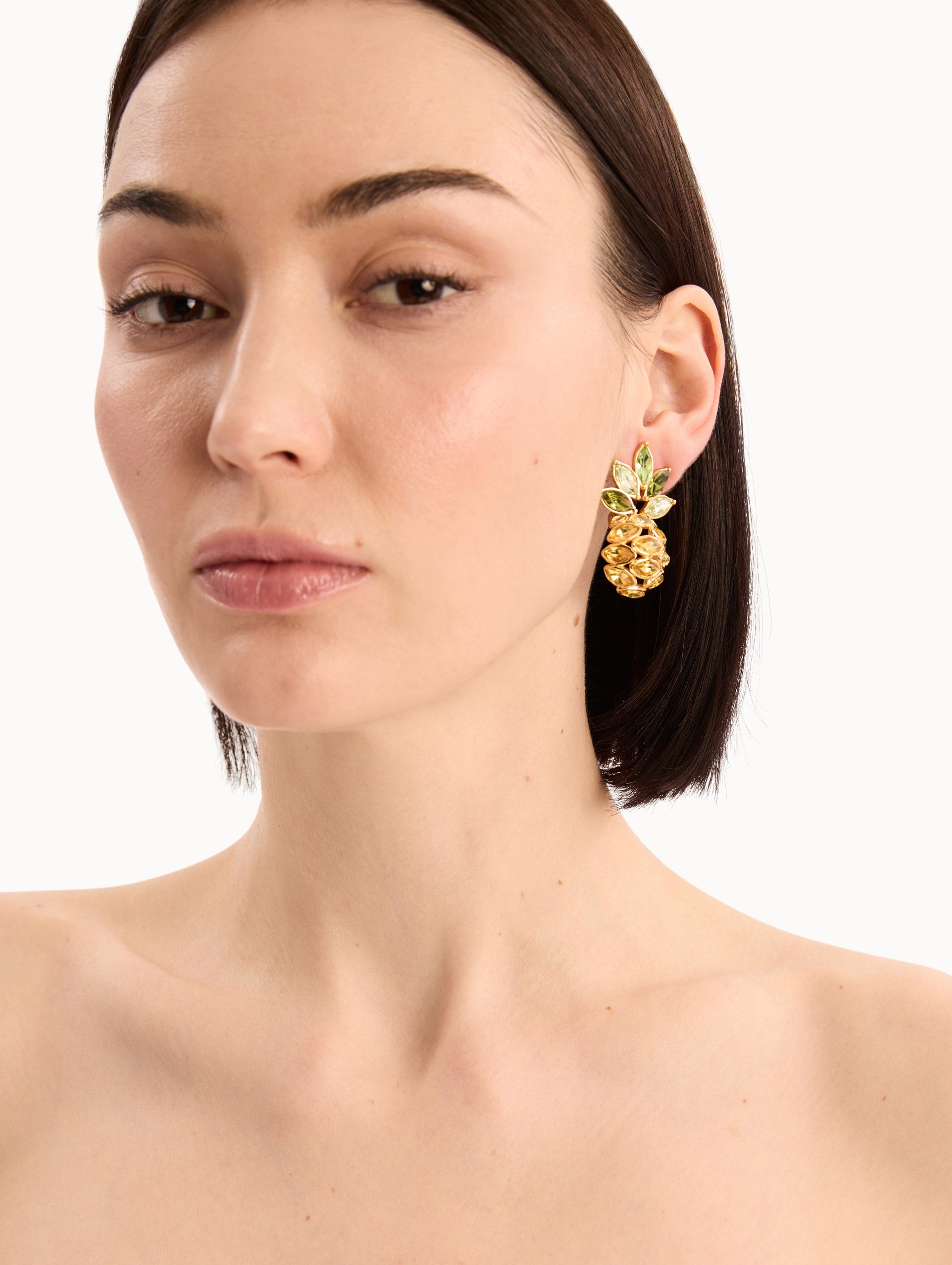 The model is wearing the Pineapple Crystal Leaf Clip-On Earrings in Citrine. Detail View.