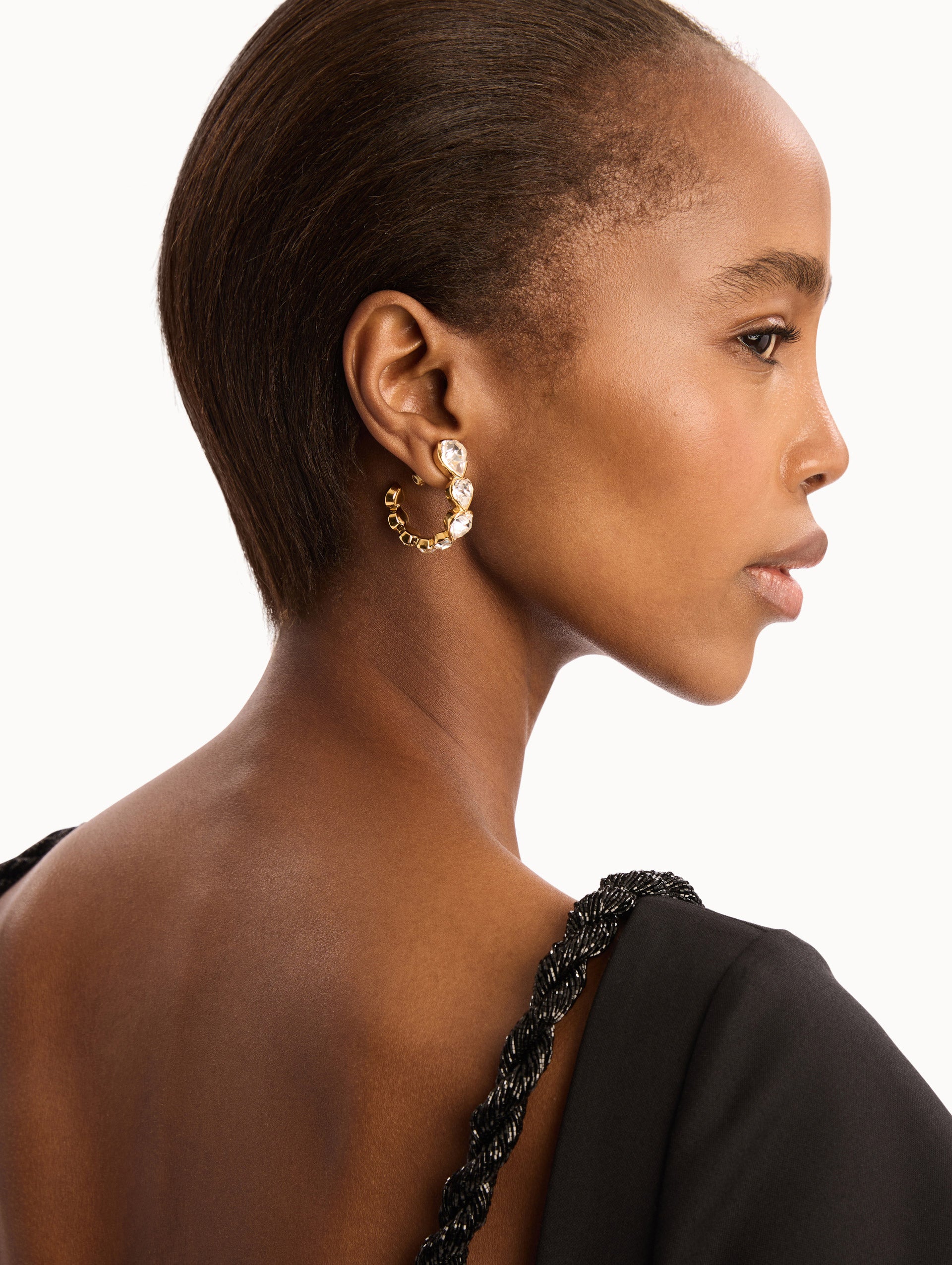 The model is wearing the Crystal Heart Hoop Earrings. Detail View.