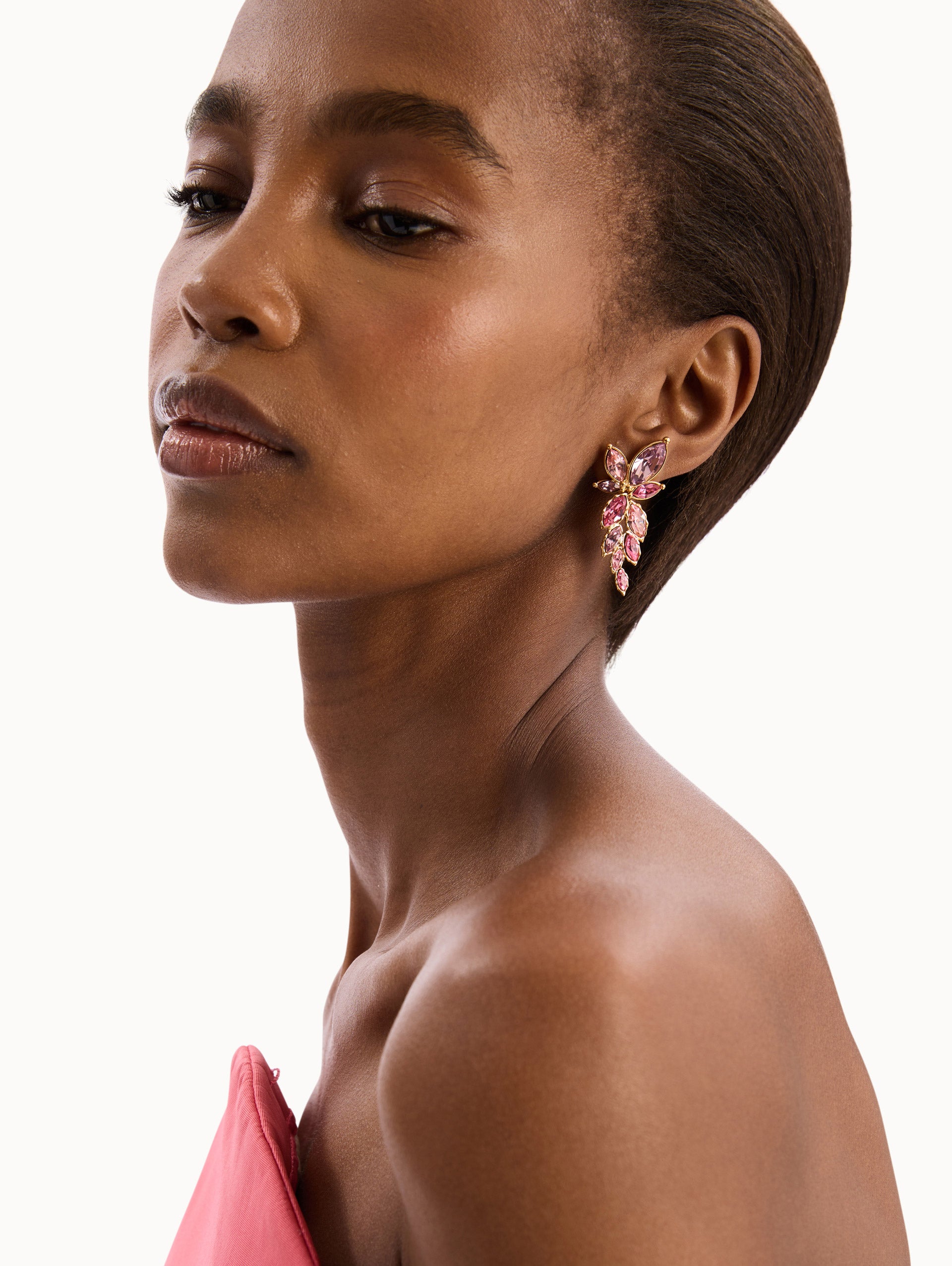 The model is wearing The Navette Crystal Drop Clip-On Earrings in Rose. Detail View.