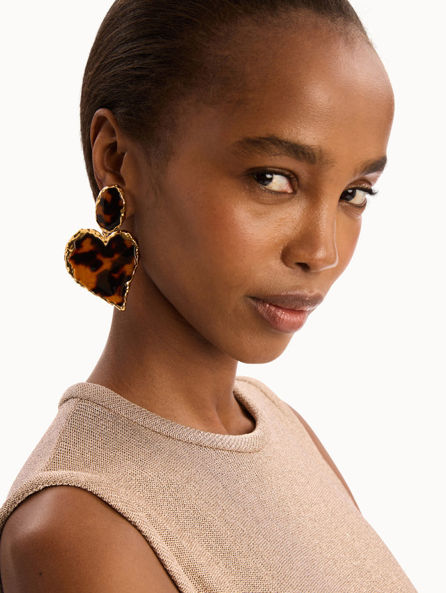 The model is wearing the Tortoise Stone Heart Clip-On Earrings in Gold and Tortoise. Detail View.