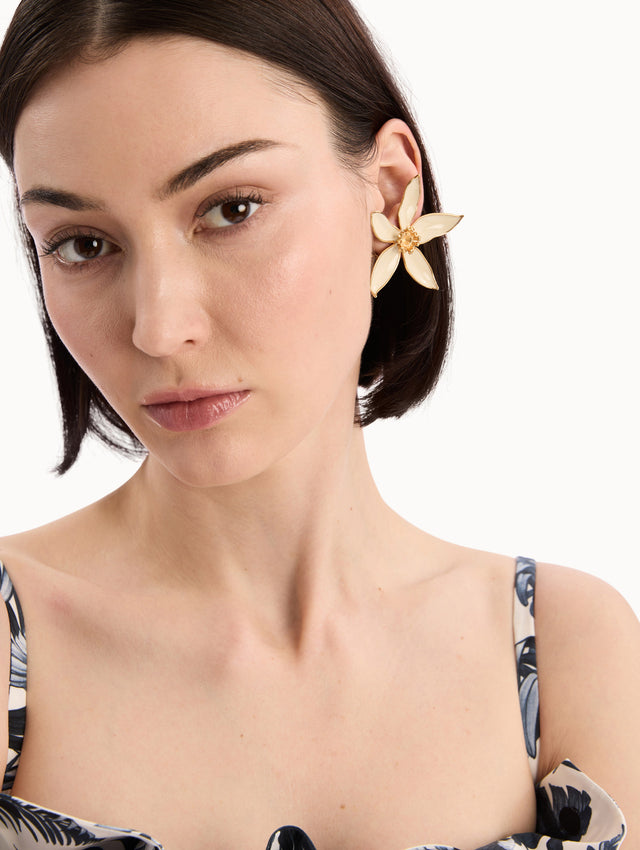 The model is wearing the Orange Blossom Clip-On Earrings in White. Detail View.