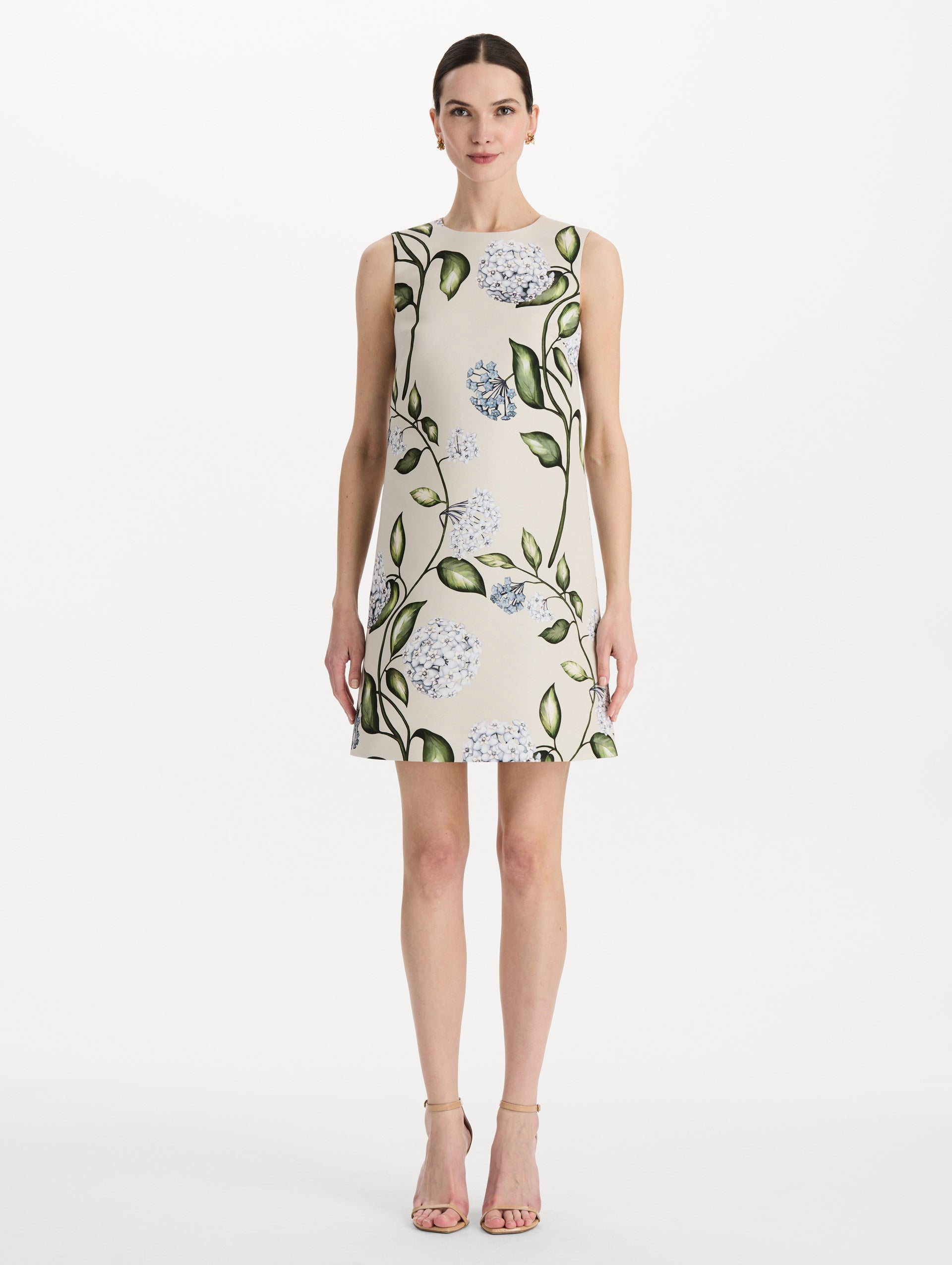 The model is wearing the Porcelain Flower Faille Shift Dress in white featuring a mini-length and printed floral motif. Front View.