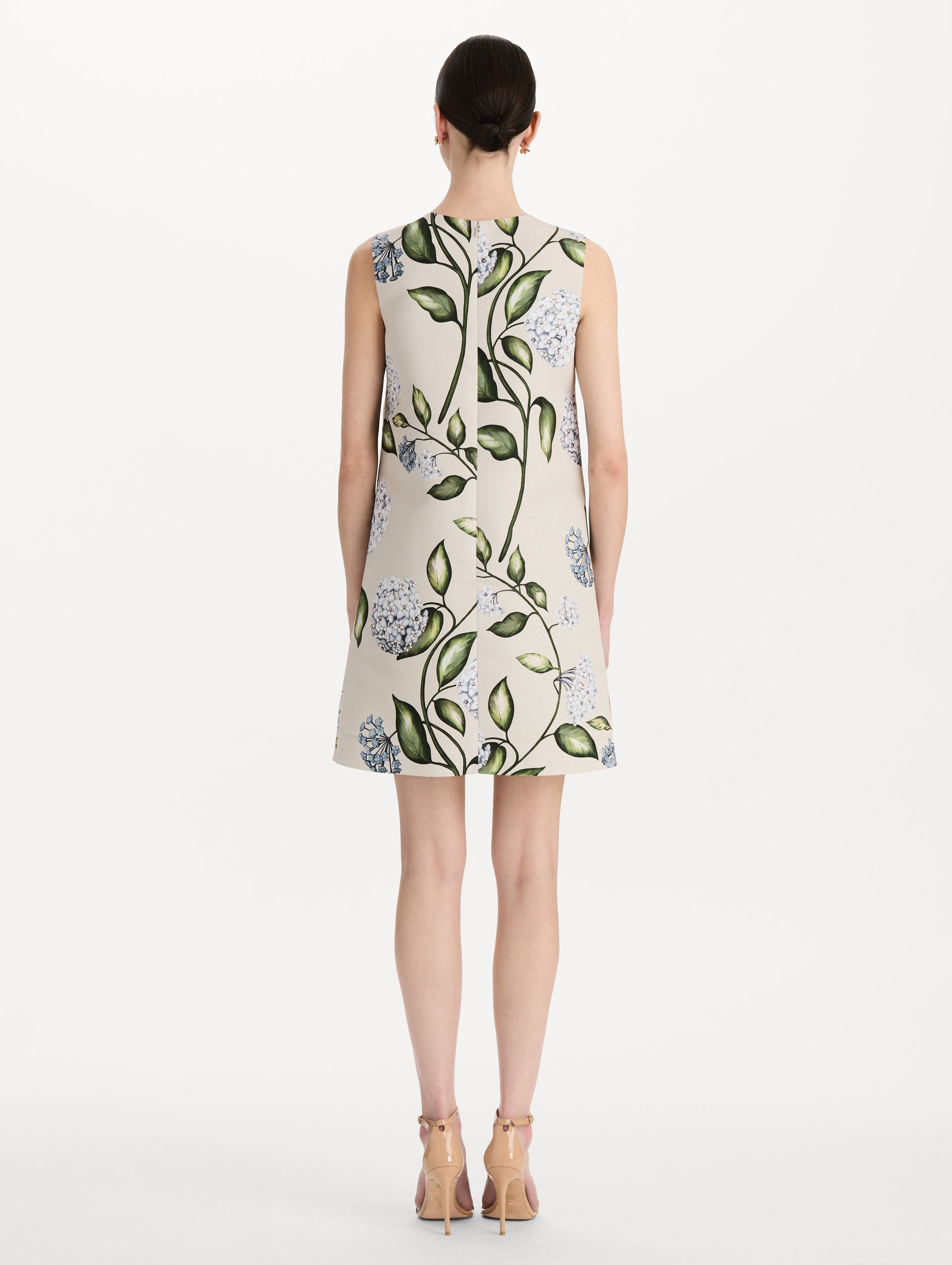 The model is wearing the Porcelain Flower Faille Shift Dress in white featuring a mini-length and printed floral motif. Back View.