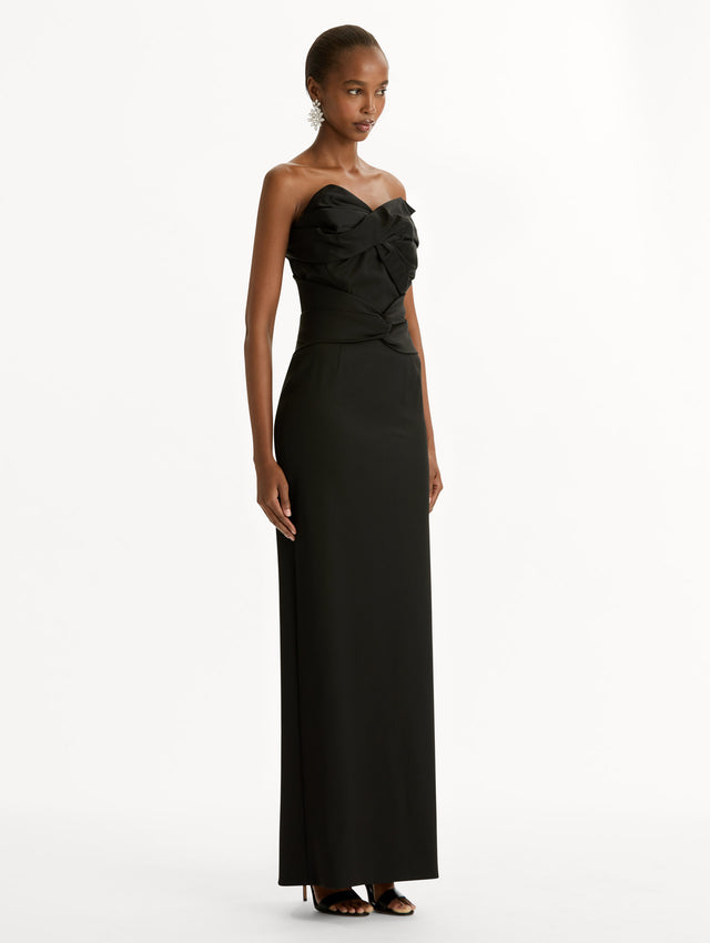 Black dress with bow detailing and a strapless, asymmetric neckline. Side View.