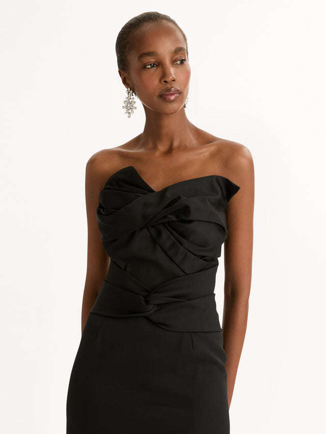Black dress with bow detailing and a strapless, asymmetric neckline. Zoom View.